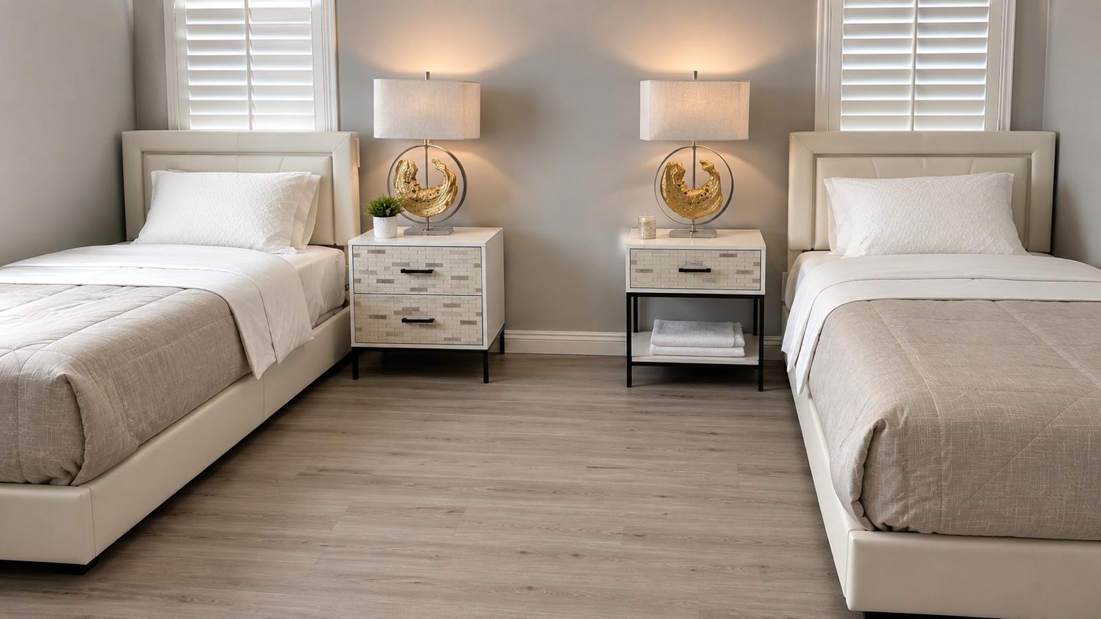 Shared bedroom with two beds, soft linens, and warm bedside lighting